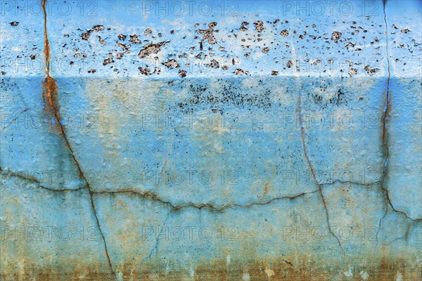 Dirty broken wall in a swimming pool, cracks, peeling blue colour, dilapidated swimming pool, lost
