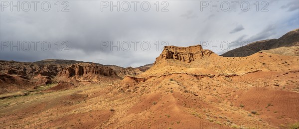 Eroded mountain landscape with sandstone cliffs, red and orange rock formations, Konorchek Canyon,