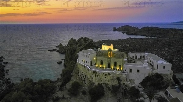 Drone shot, Gesmates Monastery, sea, illuminated church, illuminated chapel, dusk, sunset, cloudy