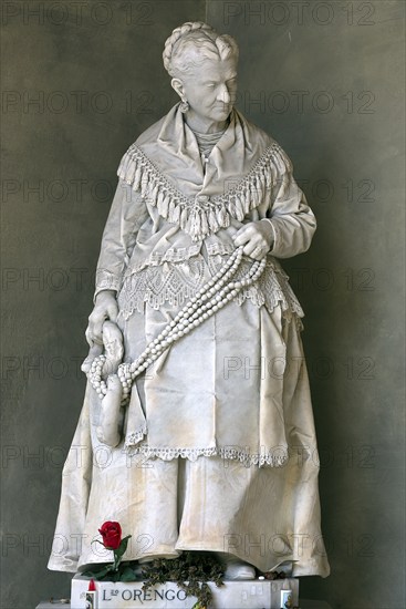 Marble sculpture of an old lady with a splendid robe, grave in the Staglieno Monumental Cemetery,