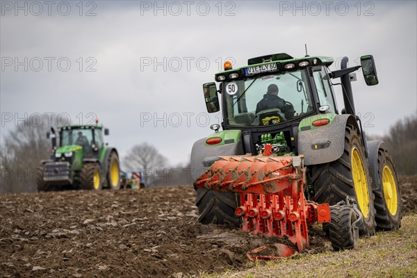 Tractor with a plough preparing the soil of a field for planting, Agriculture, Spring