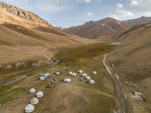 Aerial view, yurts in a mountain valley with a gravel road, Naryn region, Kyrgyzstan, Asia