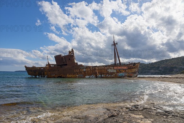 Rusty shipwreck on a sunny beach with blue sky and clouds, Shipwreck Dimitrios, Glyfada beach,