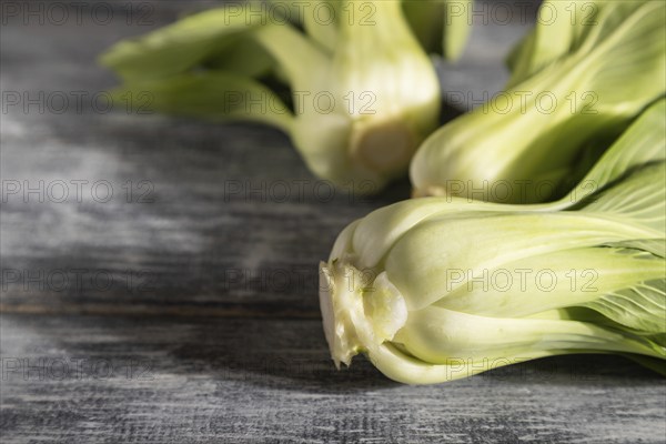 Fresh green bok choy or pac choi chinese cabbage on a gray wooden background. Hard light, contrast.