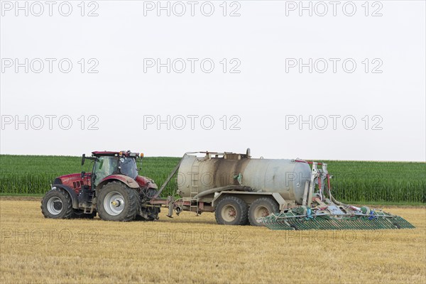 Farmer spreading liquid manure on harvested grain field, Swabian Alb, Baden-Württemberg, Germany,