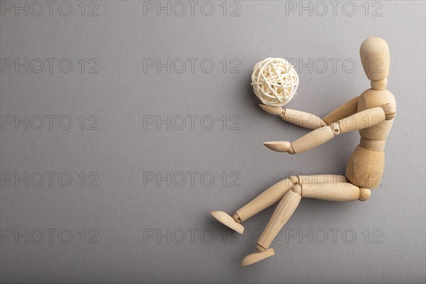 Wooden mannequin playing football on gray pastel background. copy space, isolated, sports concept