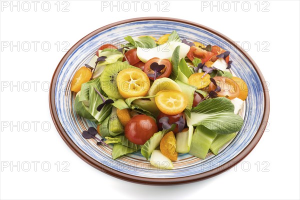 Vegetarian salad of pac choi cabbage, kiwi, tomatoes, kumquat, microgreen sprouts isolated on white