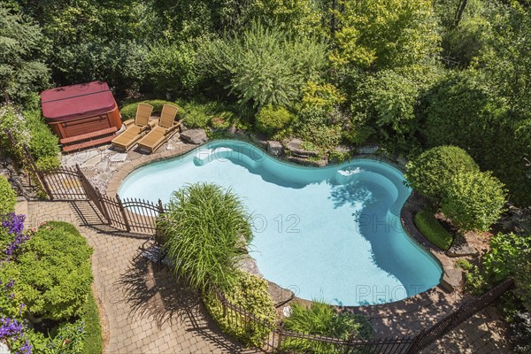 Top view of in-ground swimming pool surrounded by copper coloured wrought iron metal security fence