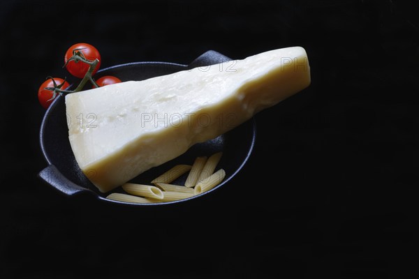 A piece of Parmesan cheese with tomatoes and pasta, Italy, Europe