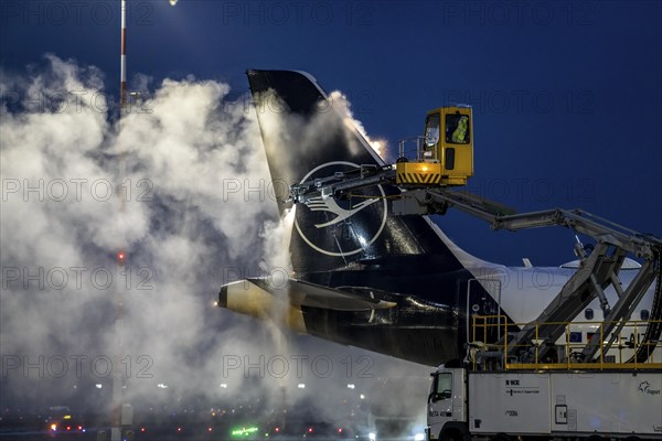 Winter at Frankfurt Main Airport, FRA, Lufthansa aircraft being de-iced by de-icing vehicles,