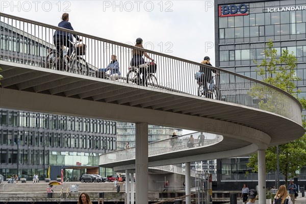 Cyclists on the Cykelslangen cycle and pedestrian bridge, at the Fisketorvet shopping centre,