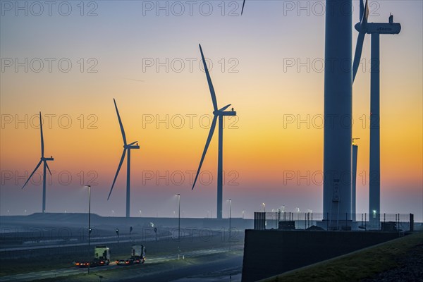 Lorry on the road from Euromax Terminal Rotterdam, ENECO wind farm on the dike around the port of