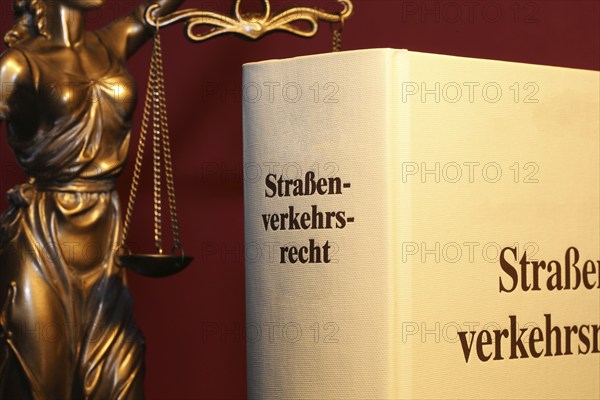 Symbolic image: Textbook on traffic law and a Justitia