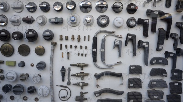 View into the shop window of an antiquarian plumbing shop with numbered spare parts of all kinds,