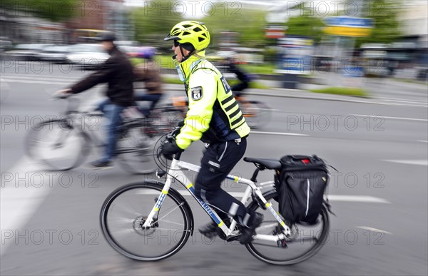 A policewoman from the Berlin bicycle squadron accompanies the bike parade demonstration, Berlin,