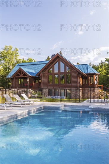 In-ground salt water swimming pool and brown stained milled Eastern white pine timber and flat log