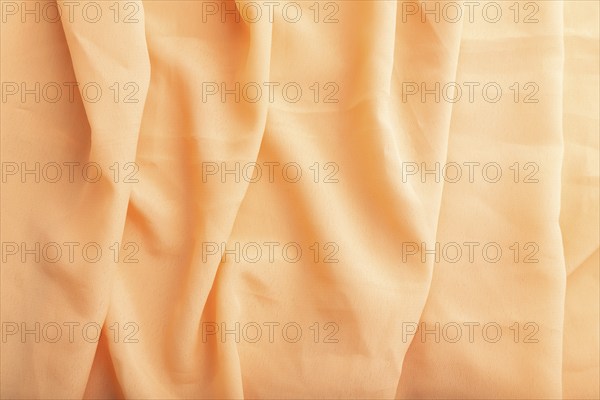 Fragment of orange linen tissue. Top view, natural textile background and texture. wave concept,
