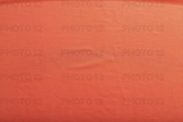 Fragment of smooth red silk tissue. Top view, flat lay, natural textile background and texture
