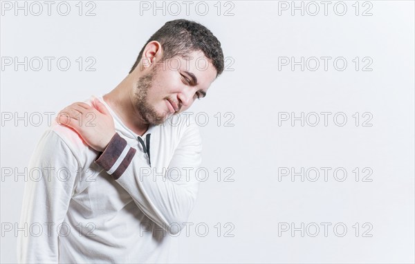 Person with shoulder muscle pain on isolated background. Unhappy man with shoulder pain isolated