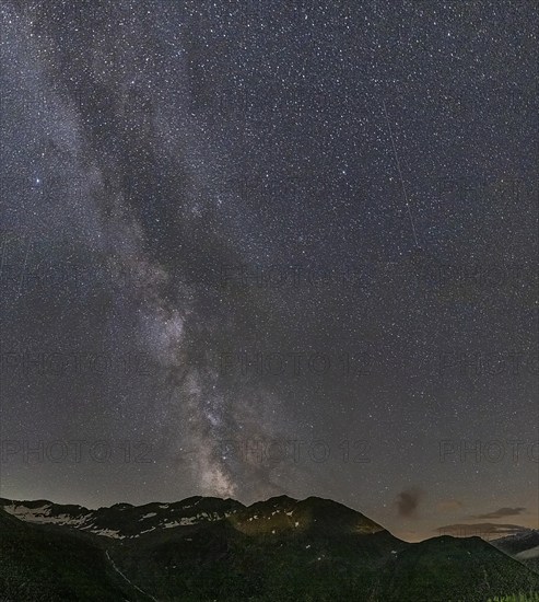 Nocturnal starry sky over the Furka Pass in the Swiss Alps. The night photograph shows the stars of