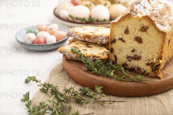Homemade easter pie with raisins and eggs on plate on a gray concrete background and linen textile.