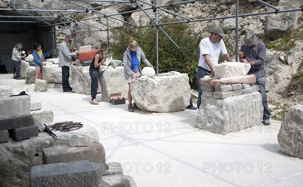 Sculptors working on local Portland stone in a community open air studio space at Tout Quarry, Isle