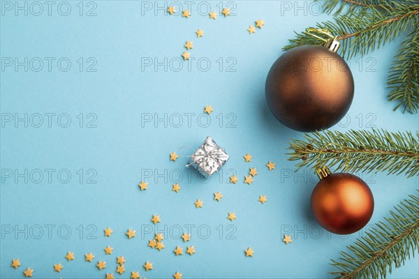 Christmas or New Year composition. Decorations, bronze balls, fir and spruce branches, on a blue
