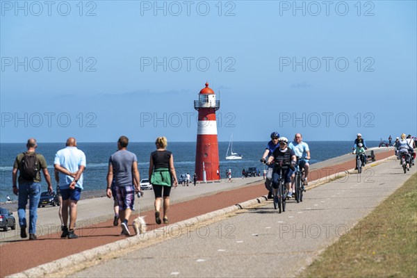 North Sea dyke near Westkapelle, Westkapelle Laag lighthouse, cyclists on the Zeeuwse Wind Route