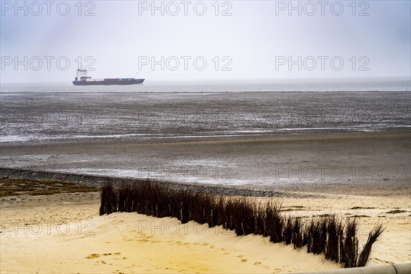 Thick fog in winter, hangs over the mouth of the Elbe into the North Sea, cargo ship enters the