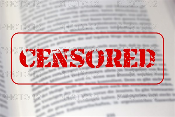Symbolic image of the debate on the so-called cancel culture with an open book and a large red