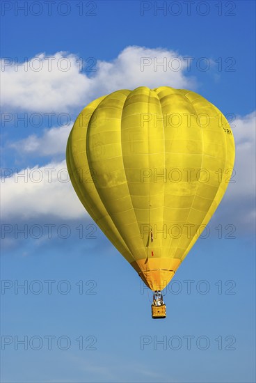 A yellow hot air balloon rises into the air as part of the aviation festival on the Rossfeld in