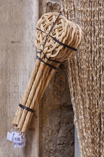 Carpet beater hanging in front of a shop for sale, Asciano, Tuscany, Italy, Europe