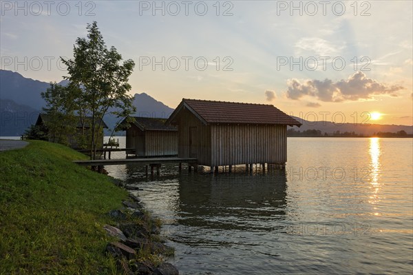 Boat huts with wooden jetty, lakeside promenade, sunset on Lake Kochel near Kochel am See, Bavarian