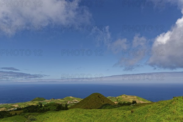 Sweeping views over green volcanic hills that gently fade into the sea under a big sky, Caldeira