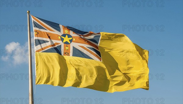 The flag of Niue, an island state in the Pacific Ocean, flutters in the wind, isolated against a