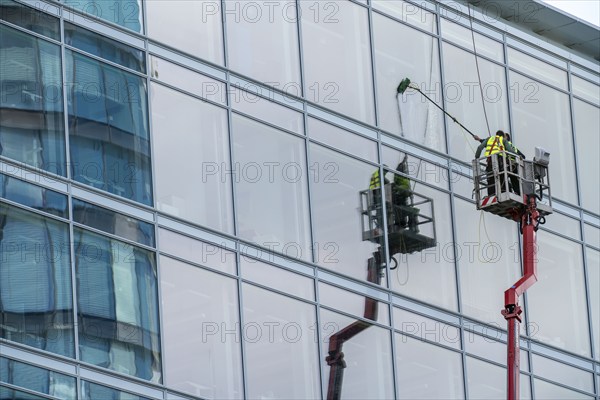 Window cleaner, building maintenance, facade cleaning, on a cherry picker, in Düsseldorf, North