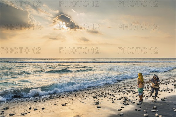 Muslim woman in the evening sun at Mangsit beach in Sengiggi, Islam, religion, headscarf, travel,