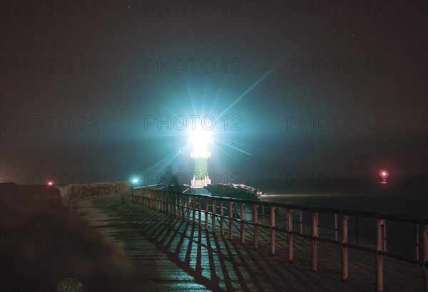 A lighthouse on the pier shows ships the way to Rostock harbour, Warnemünde, 09.02.2023