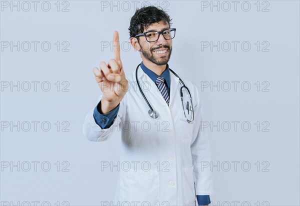 Doctor counting number ONE isolated. Handsome doctor counting number 1 on isolated background.