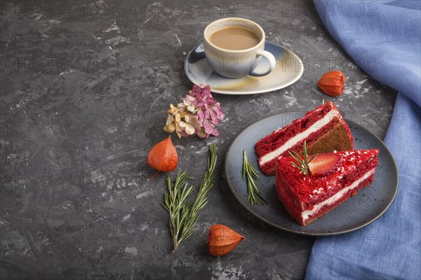 Homemade red velvet cake with milk cream and strawberry with cup of coffee on a black concrete