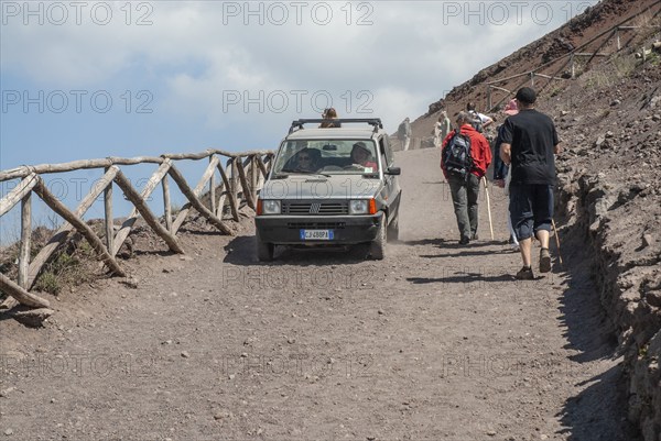 Car traffic and walking tourists on the path up to Vesuvius, near Naples, Parco Nazionale del