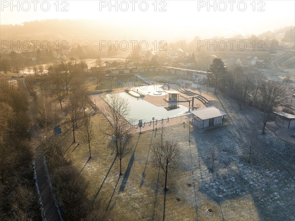 Winter morning with frosty trees and long shadows in a swimming pool, ENCW outdoor pool Calw,