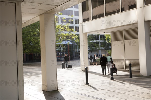 Modern architecture people walking between insurance company offices in the Tricentre development