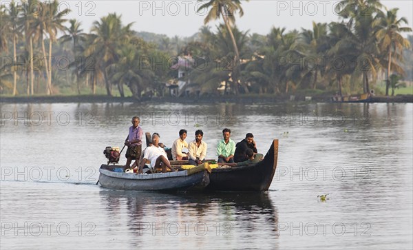 Indian men travelling on a motorboat, canal system of the backwaters, Kerala, India, Asia