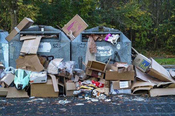 Overfilled waste paper containers, despite the overcrowding, people have put their waste paper next