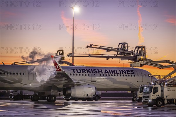 Frost at the airport, a Turkish Airlines aircraft is de-iced in front of sunrise. Airbus A321-231,