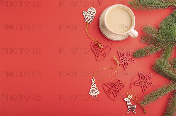 Christmas or New Year composition. Decorations, fir and spruce branches, cup of coffee, on a red