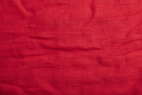 Fragment of smooth red linen tissue. Top view, flat lay, natural textile background and texture