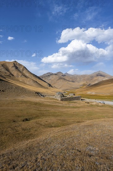 Historic caravanserai Tash Rabat from the 15th century, in the evening light with golden hills,