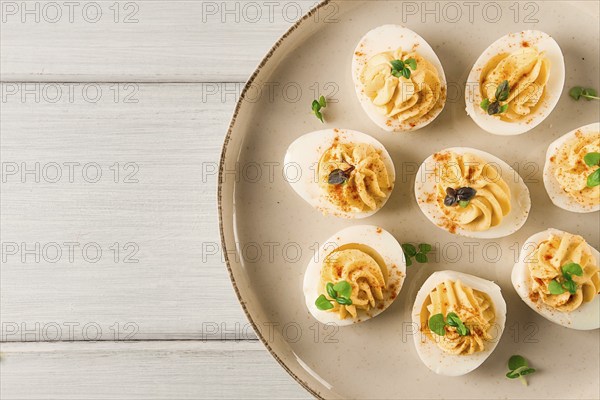 Boiled eggs stuffed with yolk with mayonnaise, on a white plate, selective focus, blurry, close-up,
